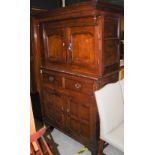 A 19TH CENTURY OAK COURT CUPBOARD, THE RECTANGULAR OVERHANGING TOP ABOVE A PAIR OF PANELLED CUPBOARD