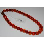 A SINGLE STRAND AMBER TYPE BEAD NECKLACE
