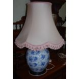 A DECORATIVE BLUE AND WHITE PORCELAIN JAR AND COVER CONVERTED TO A TABLE LAMP AND SHADE