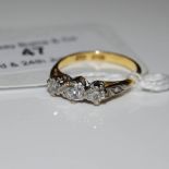 A WHITE AND YELLOW METAL THREE STONE DIAMOND RING, STAMPED 18CT, RING SIZE K