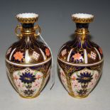 A PAIR OF ROYAL CROWN DERBY TWIN HANDLED VASES DECORATED IN THE IMARI PALETTE, 16CM HIGH