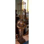 A CAST METAL TABLE LAMP IN THE FORM OF A SUIT OF ARMOUR CLASPING A HALBERD, 92CM HIGH.