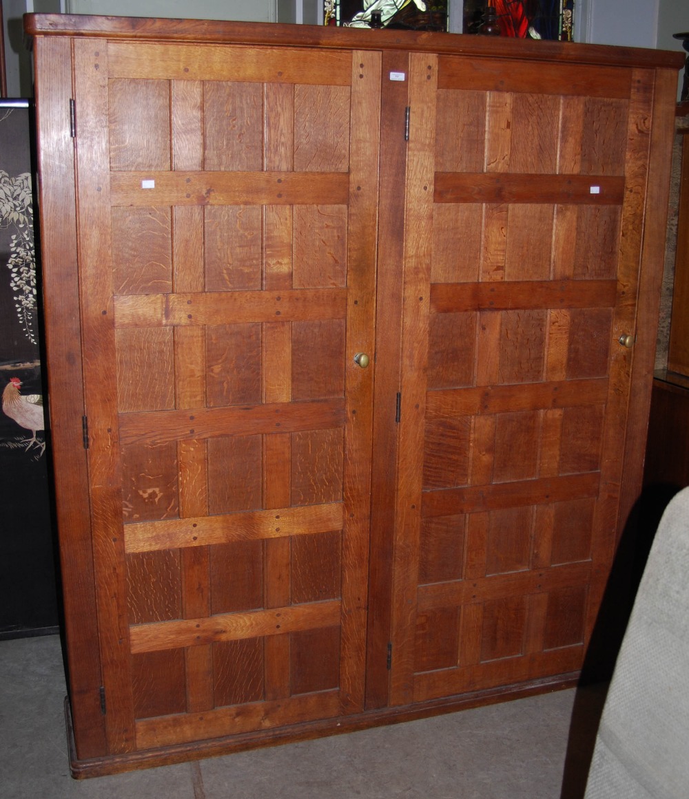 EARLY 20TH CENTURY OAK PANELLED DOUBLE WARDROBE IN THE MANNER OF THE COTSWOLD SCHOOL, THE TWO