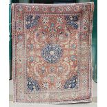 An antique Persian carpet, the madder field with palmettes and scrolling floral arabesques with a