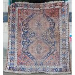 Two antique Persian carpets, both with similar tones, the larger with an indigo field set with a