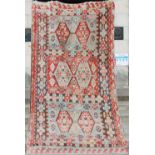 A fine flatweave Kilim carpet, the turquoise and rust red field with three panels of double