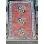 A 20th century Persian carpet, the pink field with three large hooked cream, yellow and blue