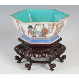 A Chinese porcelain famille rose hexagonal shaped bowl on carved wood stand, Qing Dynasty, decorated