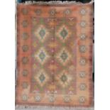 A 20th century Middle Eastern flatweave carpet, the madder field with six orange, ivory, blue and