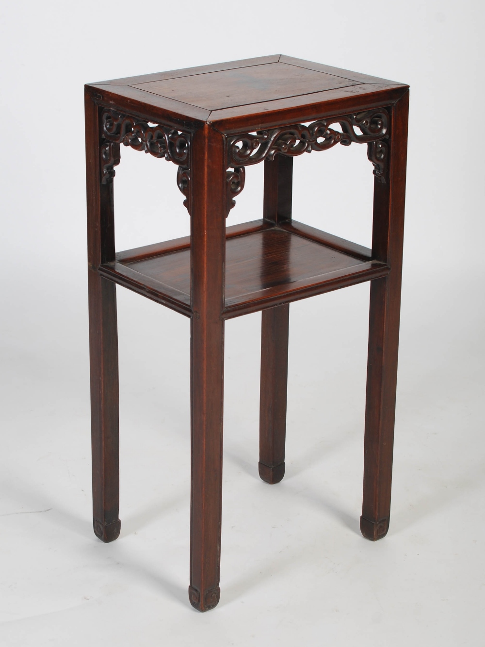 A Chinese darkwood urn stand, Qing Dynasty, the plain top with a carved scrolling frieze with