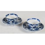 A pair of Chinese blue and white porcelain tea bowls and saucers, Qing Dynasty, moulded with leaf-