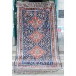 An antique Persian carpet, the indigo field with rich pattern of polychrome medallions and