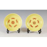 A pair of Chinese porcelain yellow ground saucer dishes, bearing Jiaqing seal marks, the interiors