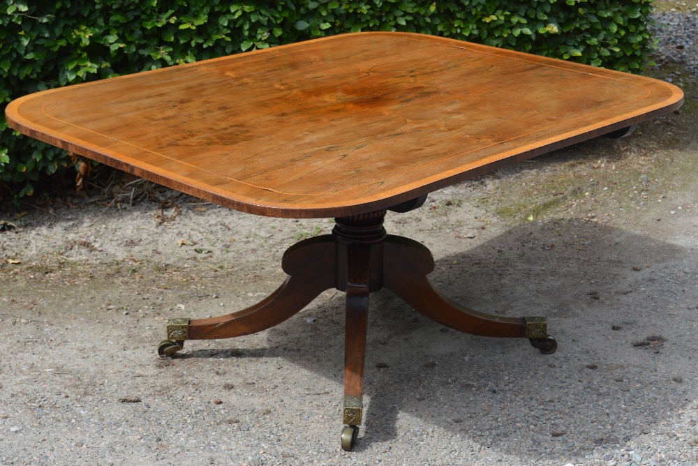 A 19th century rosewood snap top supper table, the hinged rounded rectangular top on a cylindrical