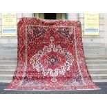 An early 20th century Persian Bakhtiari carpet, with a deep red field with a large ivory medallion