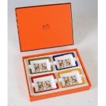 A set of four Hermes, Paris porcelain ashtrays in original fitted box, each decorated with a pair of