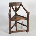 A 19th century oak turner's chair, of triangular three-post form, the back rail with hatched
