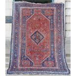 An antique Persian carpet, the deep red field with rich design around a hooked indigo diamond