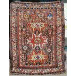 An early 20th century Persian carpet, the madder field with three red and cream medallions, in an