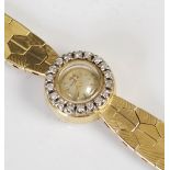 A lady's 18ct gold Omega watch with diamond set bezel, the circular dial with baton numerals, set