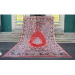 A very large antique Persian carpet, the deep red plain field with a central medallion with pendants