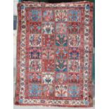 A 20th century Persian carpet, the deep red, green, indigo and ivory field with a square