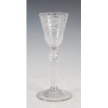 An 18th century air twist wine glass, the tapered bowl with wheel cut decoration of two six petal