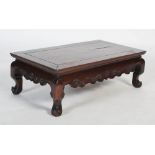 A Chinese carved darkwood kang / low table, the rectangular top with carved scrolling apron