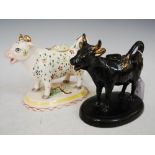 TWO 19TH CENTURY STAFFORDSHIRE COW CREAMERS, ONE BLACK WITH GILDED DETAILS THE OTHER WITH GILDED AND