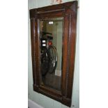 AN OAK FRAMED RECTANGULAR BEVELLED WALL MIRROR