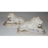 PAIR OF CARVED ALABASTER RECUMBENT LIONS RESTING ON OCTAGONAL-SHAPED PLINTHS