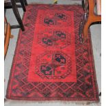 A 20TH CENTURY AFGHAN RUG, THE RECTANGULAR FIELD CENTRED WITH THREE OCTAGONAL SHAPED MEDALLIONS