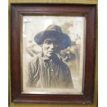 AN EARLY 20TH CENTURY PHOTOGRAPH OF A NATIVE AMERICAN INDIAN MAN SMOKING A PIPE, TITLED, SIGNED