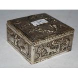 AN INDIAN WHITE METAL SQUARE-SHAPED BOX WITH EMBOSSED DECORATION OF ELEPHANTS, TIGERS, OTHER ANIMALS