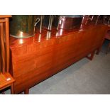 A MID CENTURY DINING ROOM SUITE COMPRISING LONG FOUR DOOR SIDEBOARD, EXTENDING DINING TABLE AND