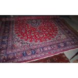 LARGE PERSIAN RUG, THE RECTANGULAR MADDER GROUND WITH ALLOVER FOLIATE DESIGN WITHIN BLUE GROUND