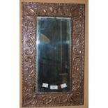 AN EARLY 20TH CENTURY BRASS WALL MIRROR, POSSIBLY SCOTTISH, WITH A WIDE EMBOSSED SCROLLING