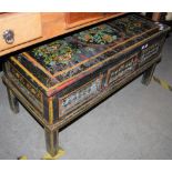 AN EASTERN PAINTED WOOD RECTANGULAR COFFEE TABLE WITH SINGLE HINGED CUPBOARD DOOR TO THE FRIEZE,
