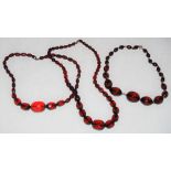 THREE GRADUATED FACETED RED AMBER TYPE NECKLACES, GROSS WEIGHT 119 GRAMS