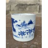 A CHINESE PORCELAIN BLUE AND WHITE BRUSH POT, QING DYNASTY, DECORATED WITH PALM TREES, PINE TREES