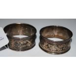 A PAIR OF BIRMINGHAM SILVER NAPKIN RINGS WITH ENGRAVED FOLIATE SCROLL DETAIL