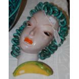 A GOLDSCHEIDER POTTERY WALL MASK IN THE FORM OF A LADIES HEAD WITH GREEN RINGLETS
