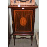 AN EDWARDIAN MAHOGANY INLAID MUSIC CABINET RAISED ON FOUR TAPERED SUPPORTS UNITED BY STRETCHERS