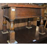 AN OAK RECTANGULAR STOOL WITH HINGED TOP AND DECORATIVE METAL HINGES