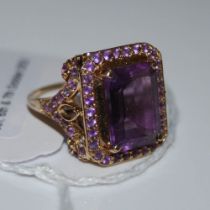 A 9CT GOLD AND AMETHYST TAJ MAHAL RING, CENTRED WITH BAGUETTE AMETHYST ESTIMATED TO WEIGH 6.92CTS,