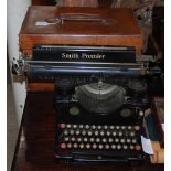 A VINTAGE BROWN LEATHER TRAVELLING CASE AND A VINTAGE SMITH PREMIER TYPEWRITER