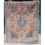 AN ANTIQUE PERSIAN CARPET, THE MADDER FIELD WITH PALMETTES AND SCROLLING FLORAL ARABESQUES WITH A