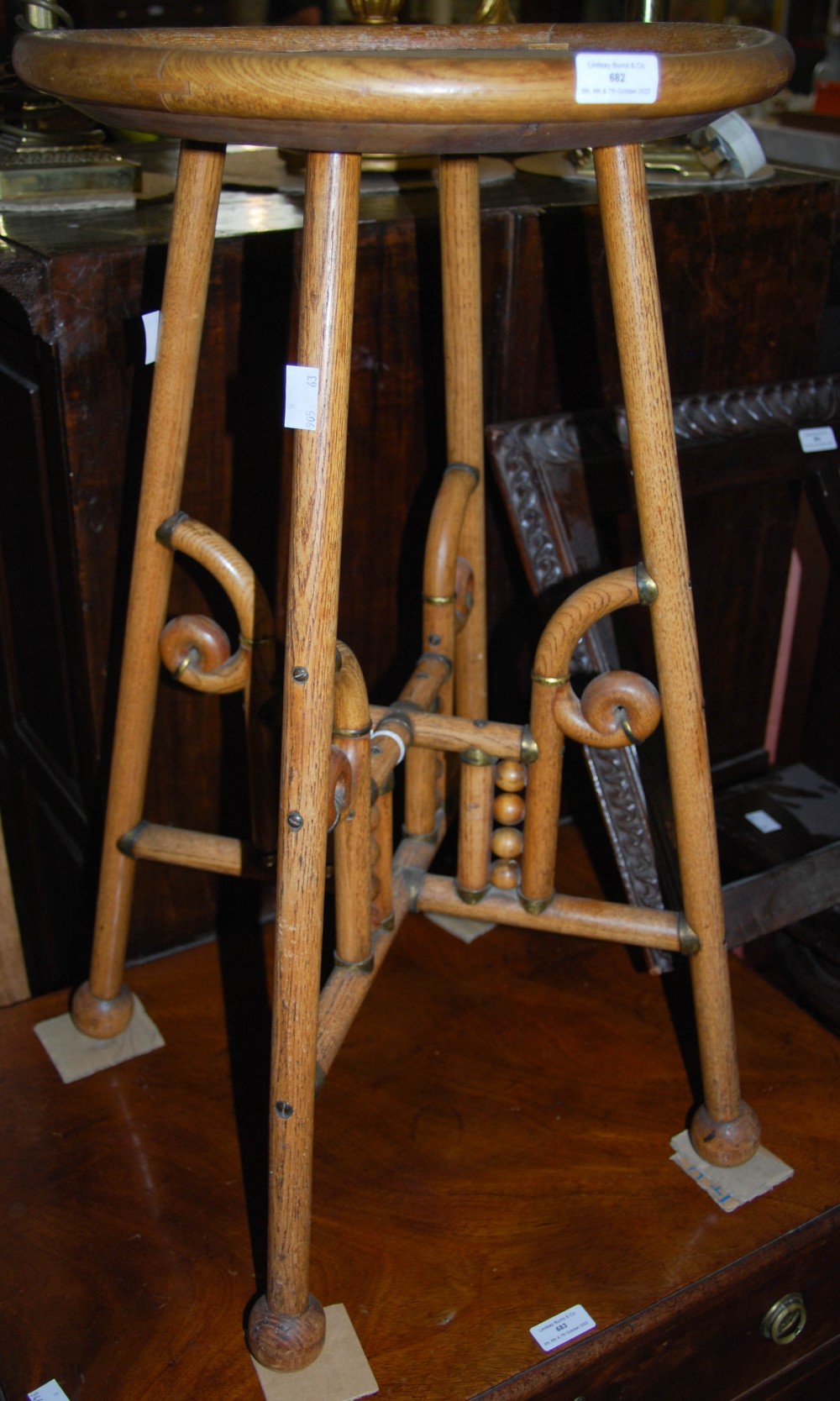 AN EARLY 20TH CENTURY CIRCULAR OCCASIONAL TABLE ON FOUR CYLINDRICAL SUPPORTS WITH BALL FEET AND