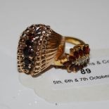 A 9CT GOLD AND GARNET SET FIVE STONE RING, TOGETHER WITH ANOTHER YELLOW METAL AND GARNET DRESS RING