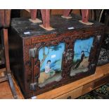 A CHINESE LACQUER TABLE TOP CABINET WITH TWO CUPBOARD DOORS DECORATED WITH REVERSE PAINTED GLASS